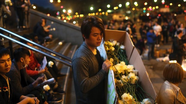 A Chinese immigrant distributes white to protesters in Paris on Thursday.