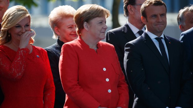 Angela Merkel, French President Emmanuel Macron and other leaders smile as US President Donald Trump speaks in Brussels on Thursday.