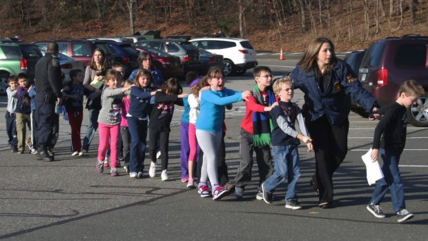 Police lead children from the Sandy Hook Elementary School in Newtown, Connecticut, where 26 people were killed in December 2012. The United States has about one school shooting a month.