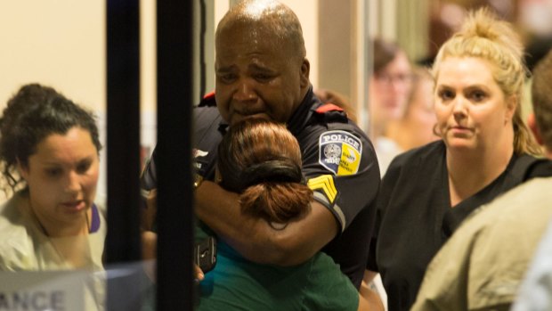 A Dallas Area Rapid Transit police officer receives comfort at the Baylor University Hospital emergency room entrance.