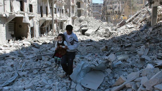 A Syrian man holds a girl as he stands on the rubble of houses that were destroyed by Syrian government forces air strikes in Aleppo, Syria.