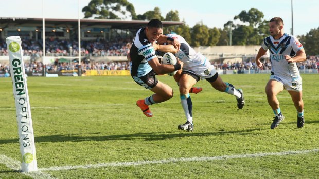 What a put down: Valentine Holmes of the Sharks is tackled as he scores try in the corner.