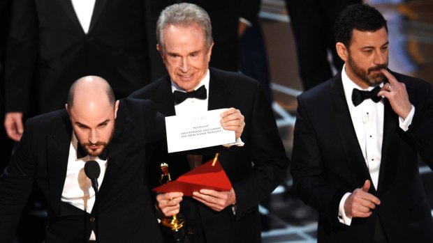 Jordan Horowitz shows the envelope revealing <i>Moonlight</i> as the real winner of best picture at the Oscars, with Warren Beatty and Jimmel Kimmel.