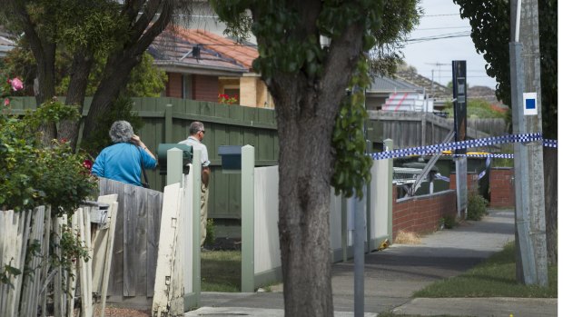 Concerned neighbours survey the scene of a homicide investigation in Thomastown.
