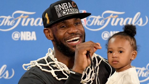 The King and his princess: LeBron James holds his daughter Zhuri during the post-game press conference.