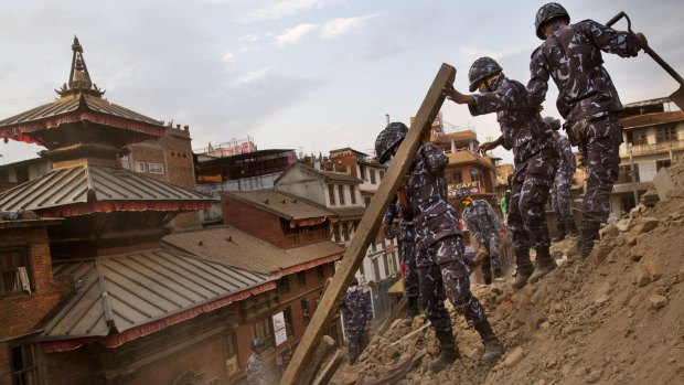 Nepalese policemen clear the debris at Basantapur Durbar Square, damaged in Saturday's earthquake, in Kathmandu.
