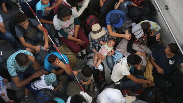 Migrants who arrived on a train from Budapest wait to be registered by the German police in Rosenheim.