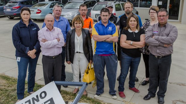 Some of the Hume business owners who are considering a class action against Telstra after they lost internet services for more than a week. They are outside a business vandalised when security cameras and systems connected through the internet failed.