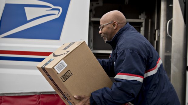 A postal worker prepares to deliver an Amazon package.
