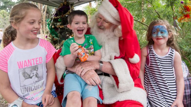 Stephen Fox charms Paige, 8, Hunter, 4, and Indi, 6, at the Kalparrin centre's Christmas party.