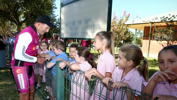 Students at St Joseph's Primary School welcome former Prime Minister Tony Abbott as he arrives in Eugowra during the 2016 Pollie Pedal tour.
