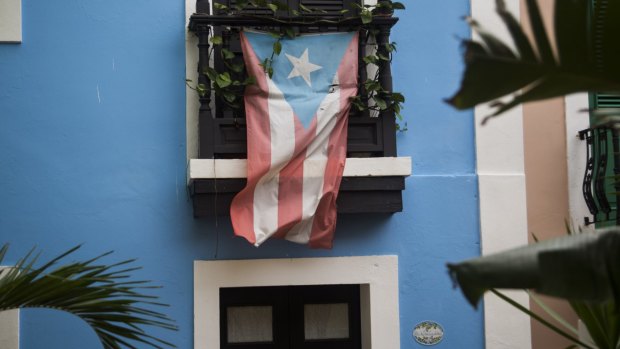 A Puerto Rican flag hangs from the balcony of a house in San Juan, Puerto Rico.
