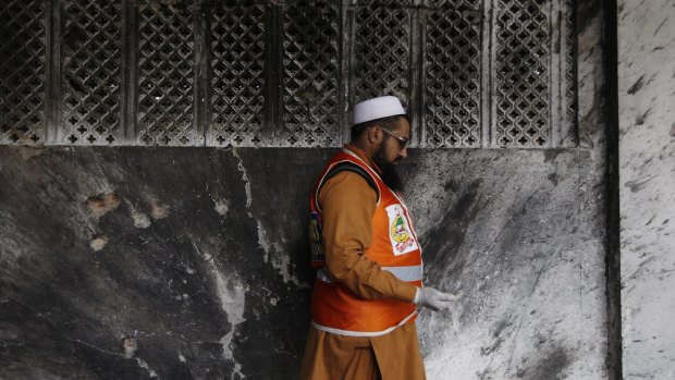 A Pakistani official collects forensic evidence at a Shiite mosque.