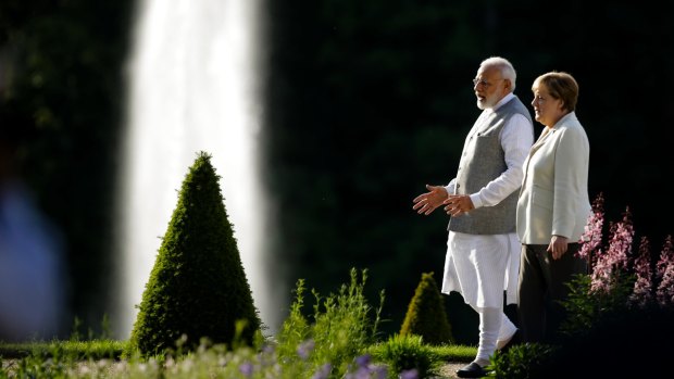 Angela Merkel and Indian Prime Minister Narendra Modi walk through the garden of the government guest house Meseberg Palace, north of Berlin, on Monday.