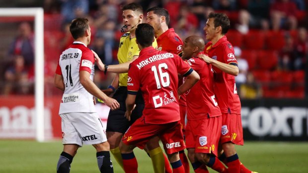 Flashpoint: Referee Shaun Evans holds back Brendon Santalab from Adelaide players after he made a hard tackle on James Holland.