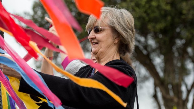 Carmel Rafferty tying ribbons on the fence outside the Holy Family parish, Doveton on Good Friday.