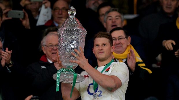 Dylan Hartley of England lifts the trophy after the final whistle.