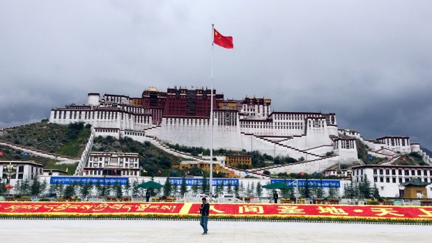 The Chinese flag flies over the Potala Palace in Lhasa Tibet. 