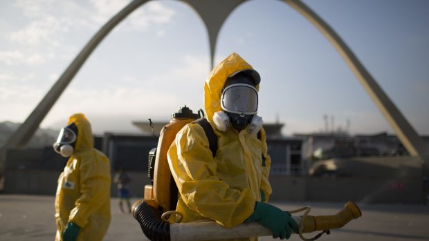 Health workers stand in the Sambadrome in Rio de Janeiro to spray insecticide.