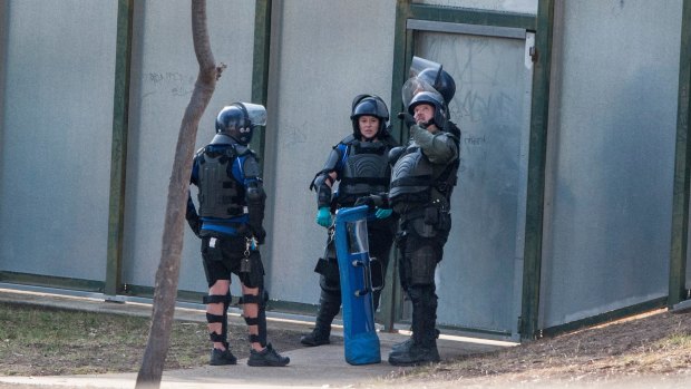 Heavily armed riot police monitor six youths who were on the roof of the Melbourne Youth Justice Centre in Parkville in March.