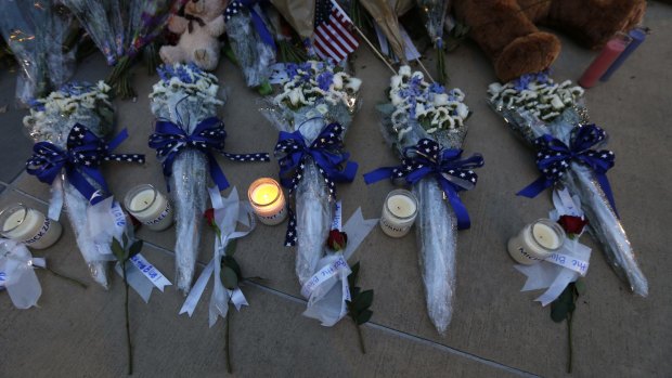 Candles and flowers placed in honor of slain Dallas police officers in front of police headquarters, in Dallas.