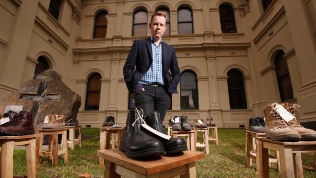 Victorian Trades Hall Council Secretary Luke Hilakari poses among the work boots symbolising workers killed on the job in the past 12 months.
