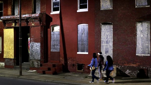 What kind of future can African-American urban youth look forward to? Women walk past blighted row houses in Baltimore. 