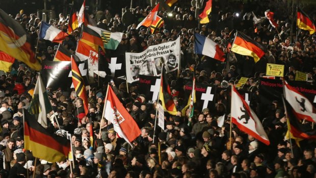 Record turnout: The anti-Islam PEGIDA marchers held a minute's silence and many wore black armbands.