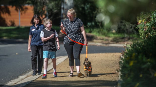 Jo Gale from the Australian Lions Hearing Dogs trainer watches progress of Amanda Sullivan with 10-year-old son, Tristan Sullivan with their new service dog Daphne. 