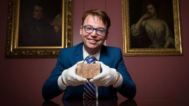 Daniel Mansfield holds the 3700-year-old Babylonian tablet that he and colleagues used to make their case.