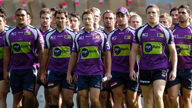 Purple pain: Storm players and coach Craig Bellamy make their defiant walk to waiting media after the scandal broke.