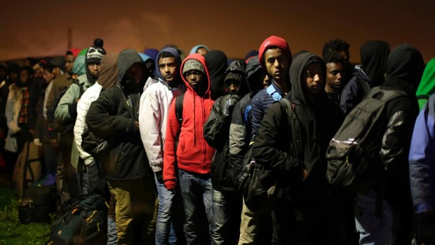 Migrants line up to register at a processing centre in the 'Jungle' camp in Calais last week.