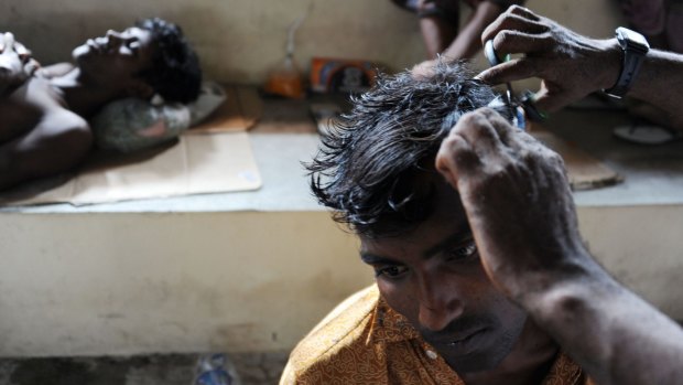A rescued migrant receives a haircut at a temporary shelter in Aceh.