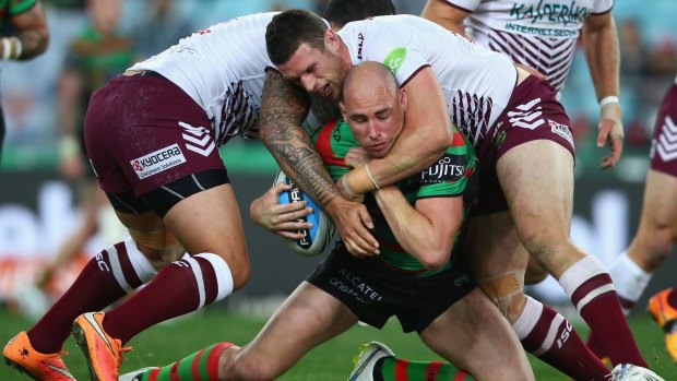 Hard yards: Ben Lowe of the Rabbitohs is swamped by Manly defenders.