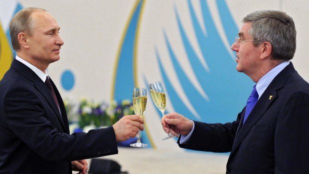 Russian President Vladimir Putin, left, toasts a glass of champagne with Thomas Bach in 2014.