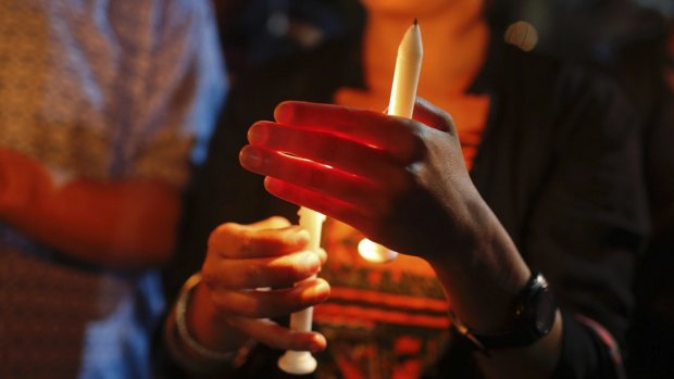 Bangladeshis light candles as they pay tribute to those killed in the attack at the Holey Artisan Bakery in Dhaka.