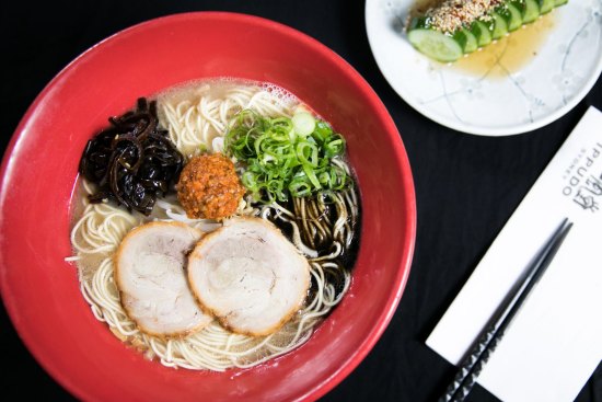 IPPUDO's famous Shiromaru Motoaji (ramen), and Spicy Goma Q (cucumber dish).