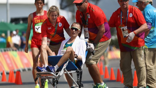 Giving all that you can give: Jared Tallent is wheeled away after crossing the finish line.
