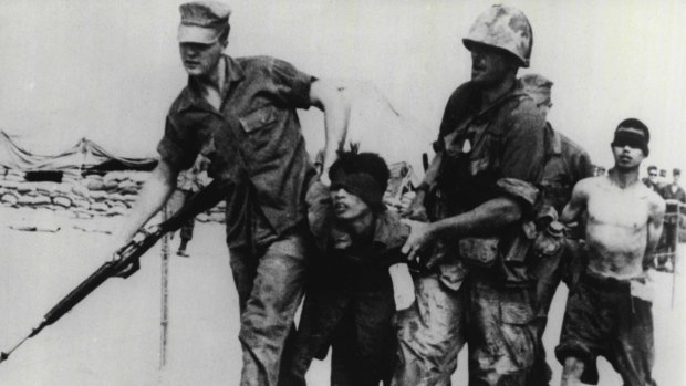An American army patrol returns with two North Vietnamese prisoners. 