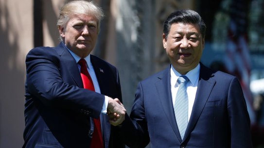 US President Donald Trump and Chinese President Xi Jinping pause for photographs on Friday.