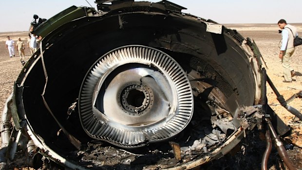 Military experts examine a piece of an engine at the crash site.