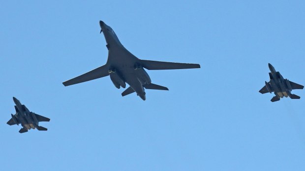 A nuclear-capable US B-1B bomber, centre, and two South Korean F-15K fighters fly over Seoul.