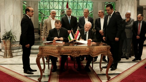 Senior Fatah official Azzam al-Ahmad (centre right) and Hamas representative Saleh al-Arouri (centre left) sign the reconciliation deal.