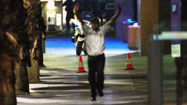 A hostage runs down Philip Street after coming out of the Lindt Cafe.