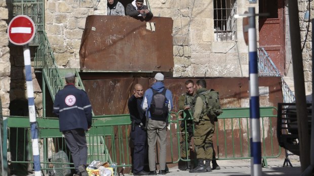 Israeli security forces stand guard as  Jewish settlers are forced out of two homes in the occupied West Bank city of Hebron on Friday.