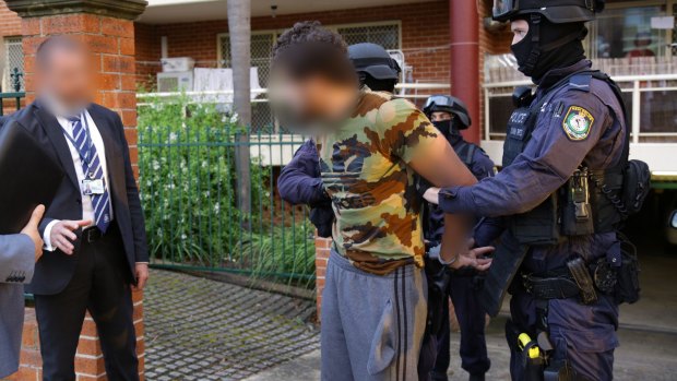 Mohamed Almaouie is taken into police custody in Bankstown. 