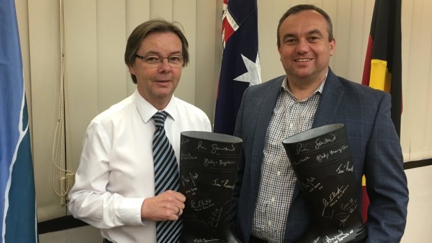 Wollondilly MP Jai Rowell hands over signed gumboots to the council on Friday.