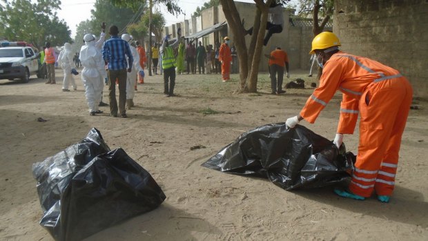 Emergency personnel collect bodies following an attack by suicide bombers at the outskirts of Maiduguri, Nigeria last month. 