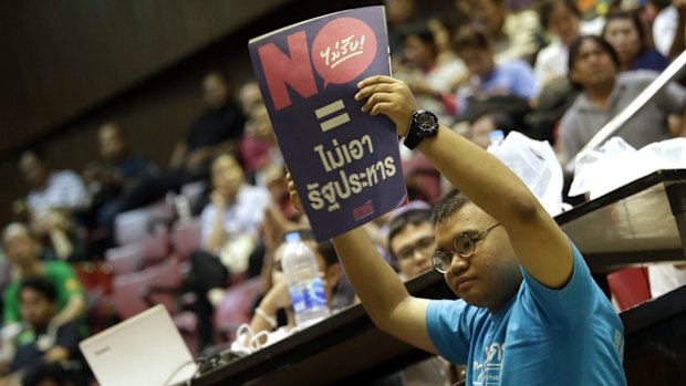 A student holds a poster reading "vote no = no coup " at Thammasat University in Bangkok on Sunday.