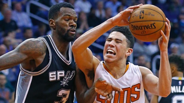 Grunt work: Phoenix Suns guard Devin Booker collides with San Antonio Spurs center Dewayne Dedmon.